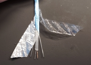 The insides of a SAS cable: tape, foil shielding, two drain wires (sides), and 2 signal conductors